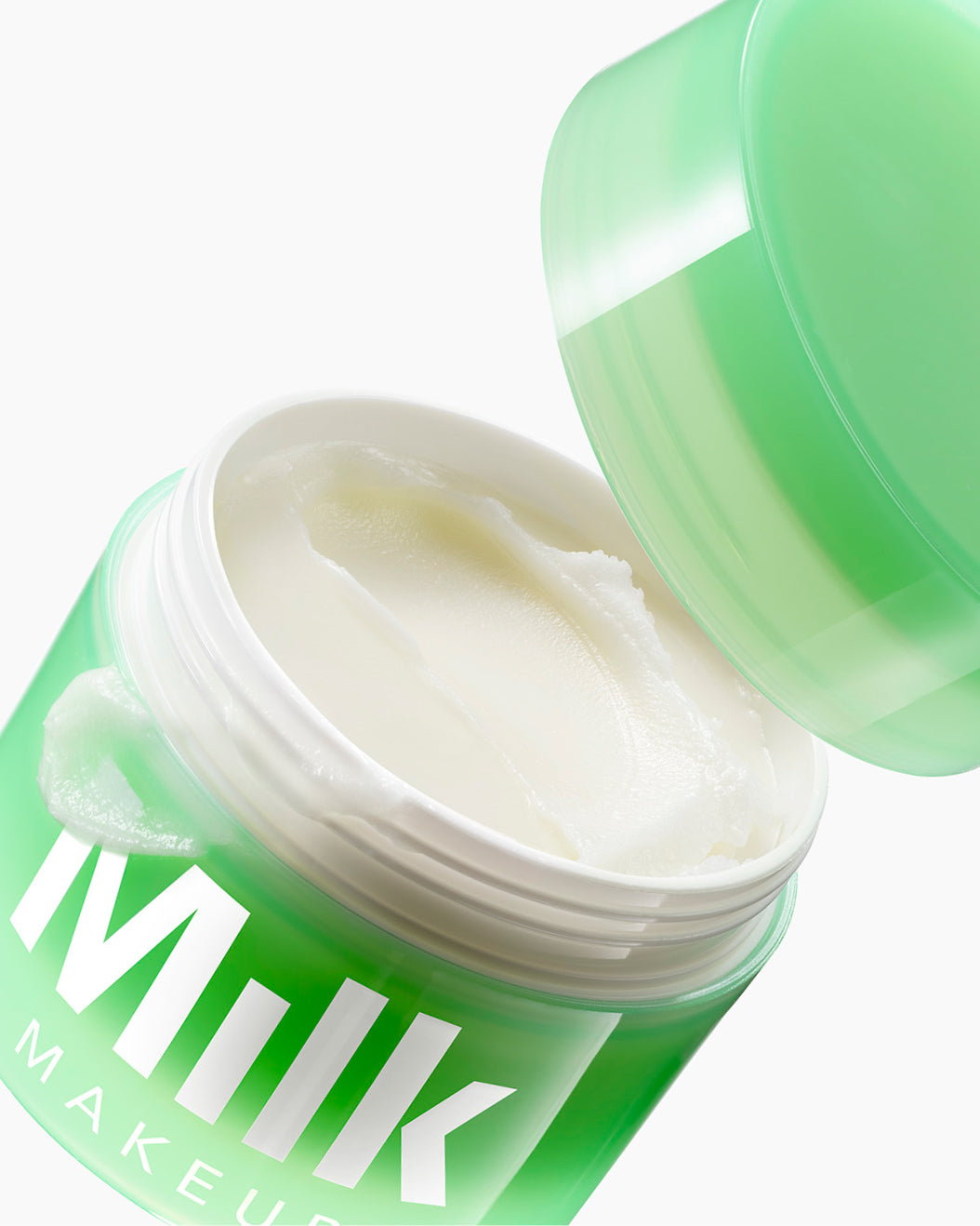 Flying jar of Milk Makeup Hydro Ungrip Cleansing Balm against a white background